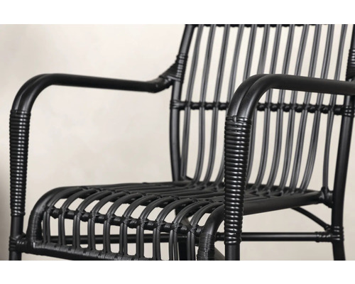 Närbild av en svart rottingfåtölj.