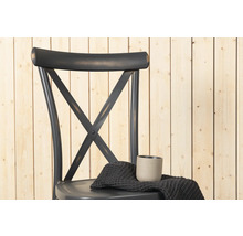 Stol med korsstag i ryggen, tyg och mugg på sitsen