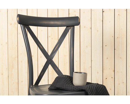 Stol med korsstag i ryggen, tyg och mugg på sitsen