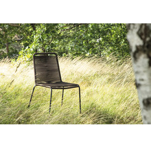 Trädgårdsscen med en modern stol av metall och rep