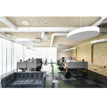 Kontorsutrymme med skrivbord, taklampor och sittplatser för anställda.