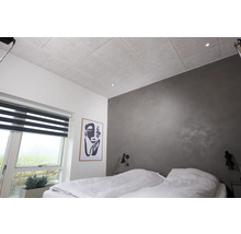 Sovrum med akustiktak, fönster med rullgardin och ett konstverk på väggen