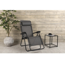 Trädgårdsscen med solstol, sidobord och krukväxt