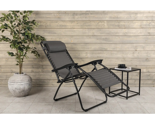 Trädgårdsscen med en relaxstol i metall med textilklädsel, ett sidobord och en krukväxt