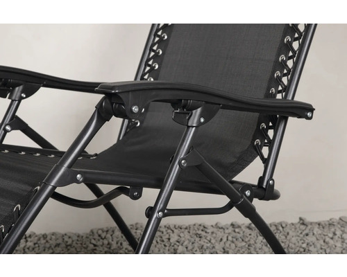 Detaljvy av en svart relaxfåtölj med metallram och textilklädsel