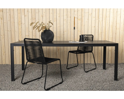 Matbord med stolar för utomhusbruk framför trävägg