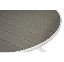 Detalj av en rund trädgårdsbordsskiva med ribbmönster och vit ram