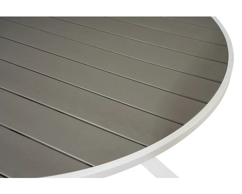 Detalj av en rund trädgårdsbordsskiva med ribbmönster och vit ram