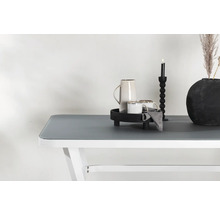 Dekorativ bordsdekoration med karaff, koppar, ljusstake och vas på ett bord