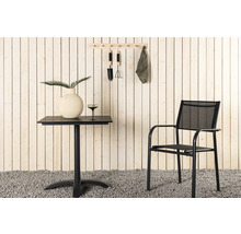 Scen med trädgårdsbord, stol och trädgårdsredskap på väggen