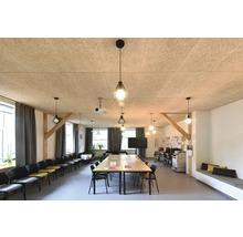 Interiör av ett ljust konferensrum med akustiktak av träull, bord, stolar och pendellampor