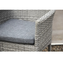 Närbild av en grå rottingfåtölj med sittdyna