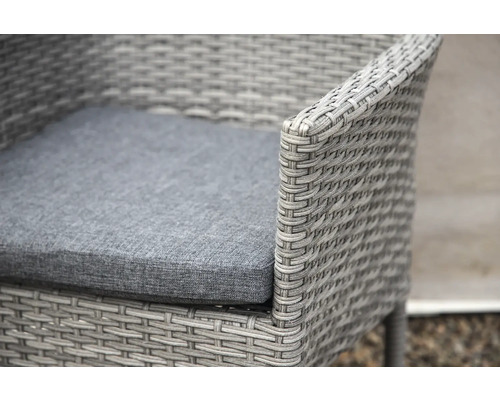 Närbild av en grå rottingfåtölj med sittdyna