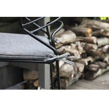 Detalj av en stol med grå sittdyna och dekorativt band