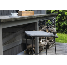 Barstol i metall med grå sittdyna framför en trävägg