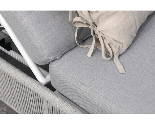 Detaljvy av en grå trädgårdsliggstol med beige kudde