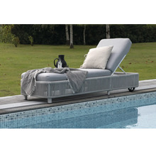 Trädgårdssäng med dyna, kudde och drycker vid poolen