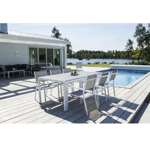 Trädgårdsscen med matbord och stolar på en träterrass bredvid en pool