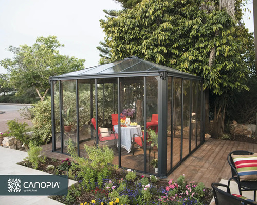 Trädgårdspaviljong med bord och stolar på en terrass