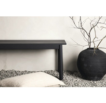 Dekorativ scen med en bänk, en kudde och en vas med grenar