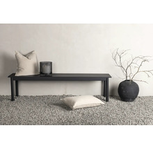 Dekorativ scen med bänk, kuddar, lykta och planteringskärl på grus