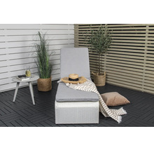 Scen med en trädgårdssäng, ett sidobord och dekorativa växter på en terrass.