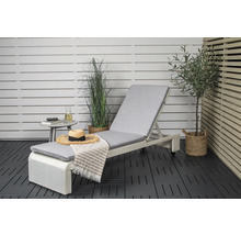 Miljöbild med solstol, sidobord och dekorationer på en balkong