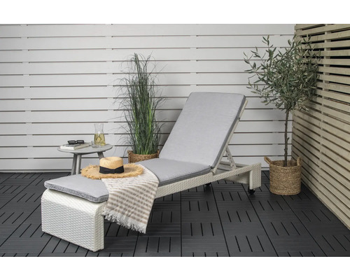 Miljöbild med solstol, sidobord och dekorationer på en balkong