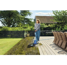 Kvinna rengör träterrass med terrasstvätt