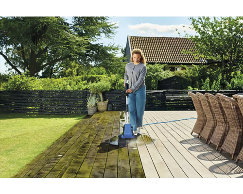 Kvinna rengör träterrass med terrasstvätt