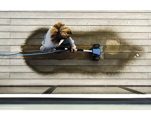 Kvinna rengör en träterrass med en terrasstvätt.