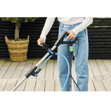 Kvinna använder en fogskrapa på en terrass.