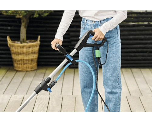 Kvinna använder en fogskrapa på en terrass.