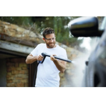 Man rengör en bil med en högtryckstvätt.