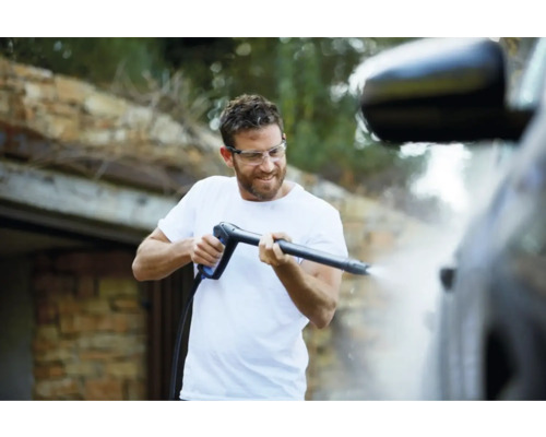 Man rengör en bil med en högtryckstvätt.