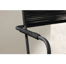 Detaljvy av en svart karmstol med repklädsel