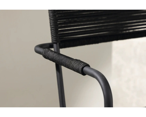 Detaljvy av en svart karmstol med repklädsel