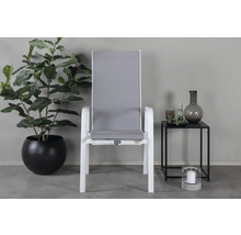 Trädgårdsscen med vit trädgårdsstol, krukväxt och sidobord