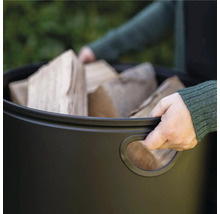 Person som bär en behållare med ved