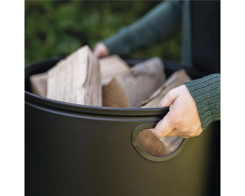 Person som bär en behållare med ved