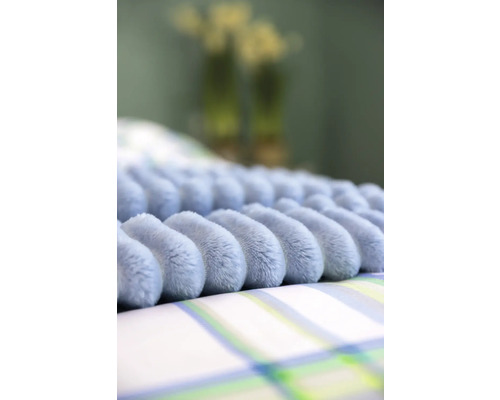 Prydnadskudde med noppmönster på sängkläder