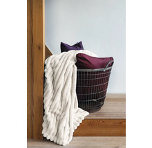 Trådkorg med filt och kuddar på en trätrappa