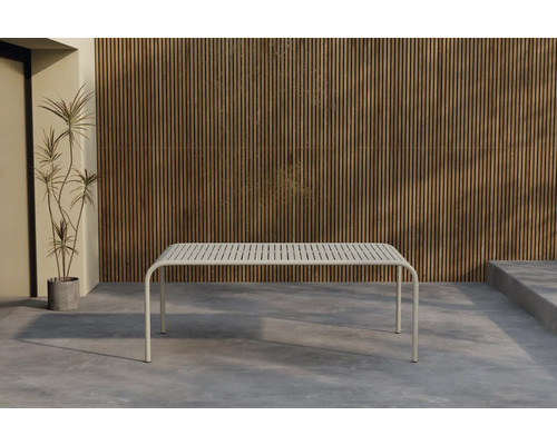 Modernt trädgårdsbord med lamellkonstruktion framför träpanelvägg