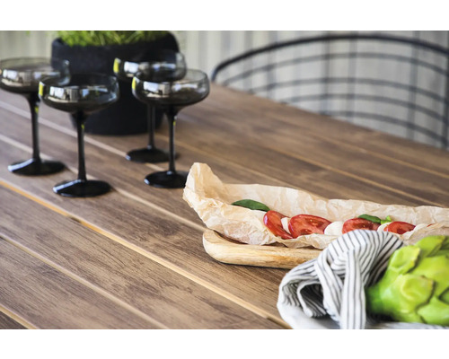 Scen med dukat träbord, glas, mat och dekoration