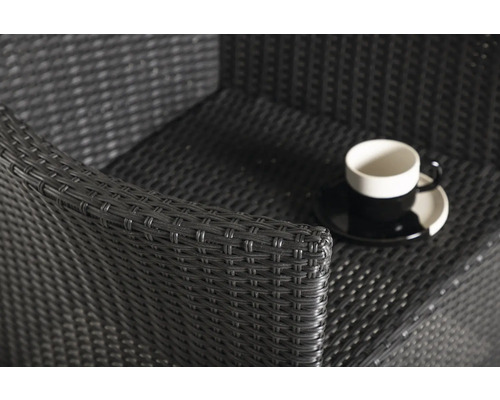 Detaljbild av en rottingfåtölj med kopp och fat