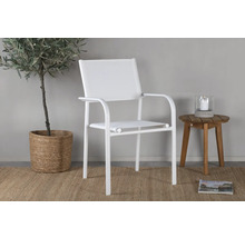 Vit metallträdgårdsstol med armstöd bredvid ett litet träbord