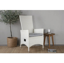 Vit rottingfåtölj med armstöd och grå kudde bredvid sidobord