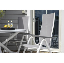 Trädgårdsscen med trädgårdsbord, två trädgårdsstolar och drycker.