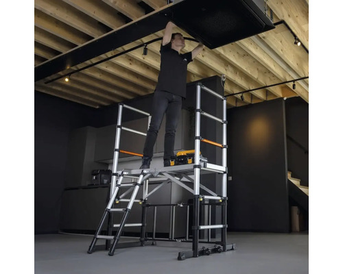 En person arbetar på en ställning i taket.