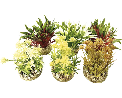 Tre konstgjorda växter i krukor med småsten